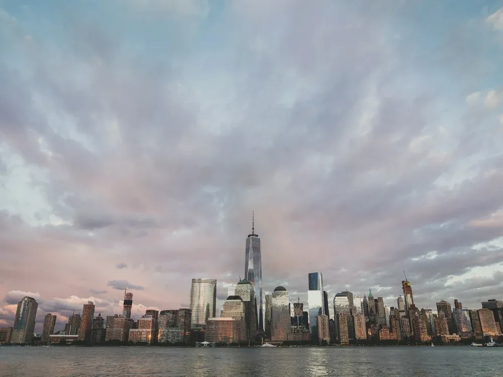 Lower Manhattan skyline across the Hudson at dusk
